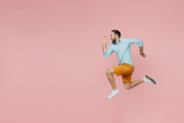 Full body side profile view young smiling caucasian man 20s wear classic blue shirt run fast jump...