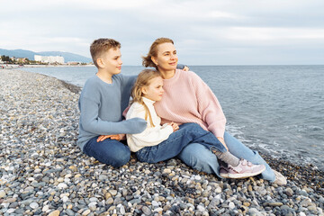 Fototapeta premium Mom and kids on the beach admiring the sunset.