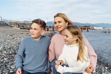 Portraits of mom and kids on the seashore at sunset.