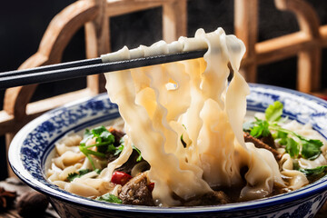 Spicy red soup beef noodle in a bowl on wooden table - obrazy, fototapety, plakaty