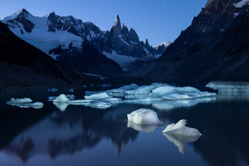 Icebergs dot the shore of Laguna Torre, illuminated at night in
