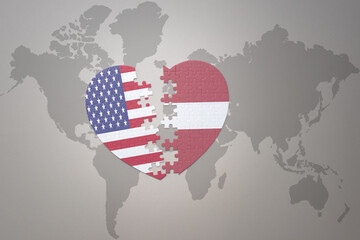 puzzle heart with the national flag of united states of america and latvia on a world map...