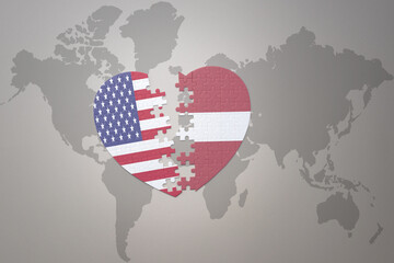 puzzle heart with the national flag of united states of america and latvia on a world map background. Concept.