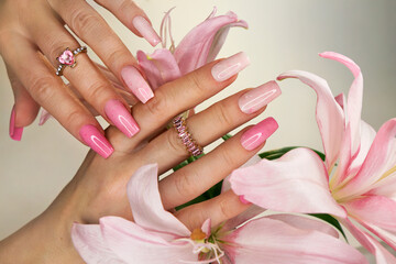 Pink elongated nail extension with fine glitter.