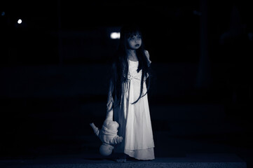 sad child ghost at night,Halloween  Festival concept,Friday 13th,Horror movie scene,A girl with doll