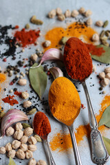 Vibrant colors of aromatic spices. Colorful still life with turmeric, paprika, peppercorns, chili, garlic, bay leaf, sea salt. Food flavoring. 