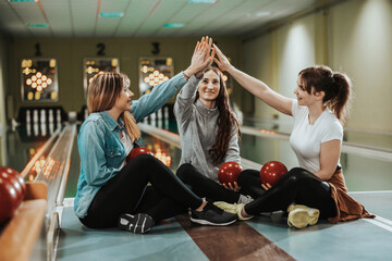 Three Female Friends Having Fun And Celebrating In A Bowling Alley