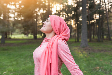 woman with cancer in nature while breathing fresh air, concept of a woman fighting cancer, woman...