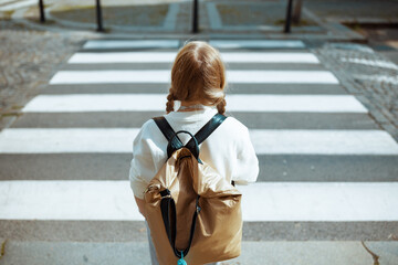 pupil crossing crosswalk and going to school outdoors in city