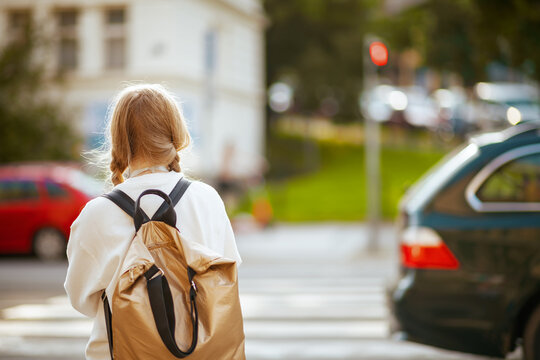 trendy school girl crossing crosswalk and going to school