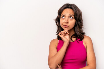 Young hispanic woman isolated on white background looking sideways with doubtful and skeptical expression.