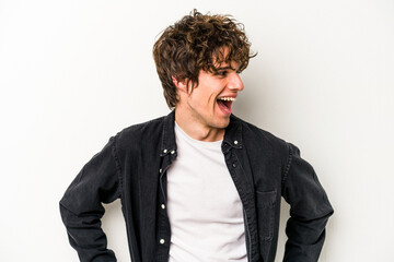 Young caucasian man isolated on white background laughs happily and has fun keeping hands on...