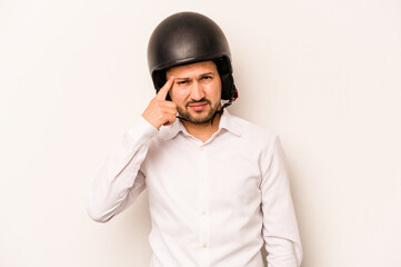 Hispanic business man going to work with motorcycle isolated on white background showing a disappointment gesture with forefinger.