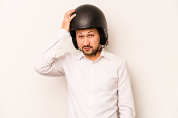 Hispanic business man going to work with motorcycle isolated on white background being shocked, she has remembered important meeting.