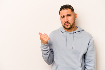 Fototapeta premium Young hispanic man isolated on white background shocked pointing with index fingers to a copy space.