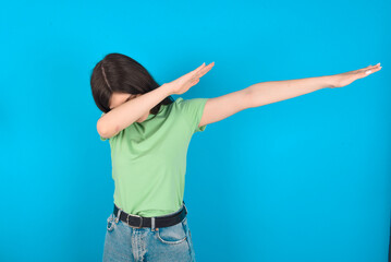 Photo of funky young beautiful Caucasian woman wearing green T-shirt over blue wall show disco move...