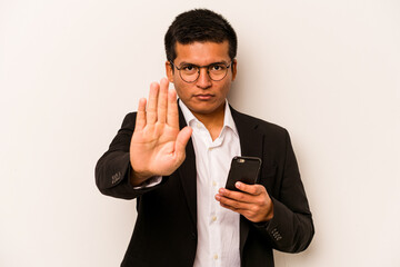 Young business hispanic man holding mobile phone isolated on white background standing with...