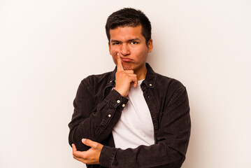 Young hispanic man isolated on white background unhappy looking in camera with sarcastic expression.