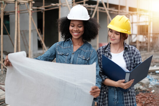 Working women concept. Architecture engineering at workplace. engineer architect wearing safety helmet meeting at contruction site. working contruction on site plans to build high-rise buildings.