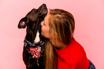 Young caucasian woman with her dog isolated on pink background