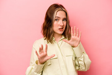 Young caucasian woman isolated on pink background rejecting someone showing a gesture of disgust.