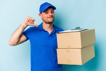 Fototapeta na wymiar Young caucasian delivery man isolated on blue background feels proud and self confident, example to follow.