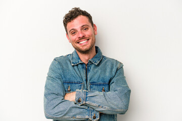 Young caucasian man isolated on white background who feels confident, crossing arms with determination.