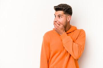 Young caucasian man isolated on white background thoughtful looking to a copy space covering mouth with hand.