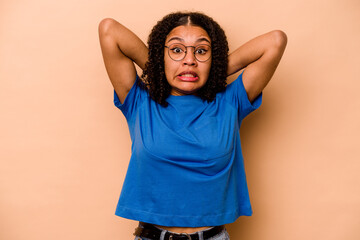 Young African American woman isolated on beige background screaming with rage.