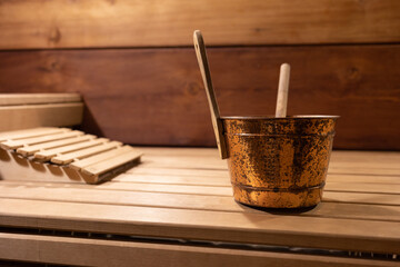 ladle on a couch in a bath in a Russian wooden bath. a metal bucket. Selective focus.