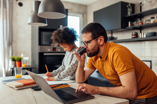 Young man drinking coffee and his daughter together working and doing homework - Powered by Adobe