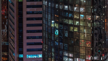 Fototapeta na wymiar Windows in office building exterior in the late night with interior lights on timelapse