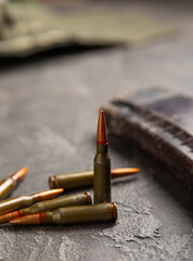 Bullets on black textured marble. Bullets of a kolashnikov assault rifle close-up with space for text. Cartridges for a rifle and a carbine on a wooden background. Military concept. copy space