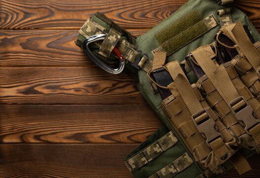 Military Body Armor With A Pouch On A Brown Textured Wood. Army Body Armor. View From Above. Place To Copy. Military Concept.