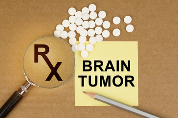 On the table are pills, a magnifying glass, pencils and a sticker with the inscription - BRAIN TUMOR