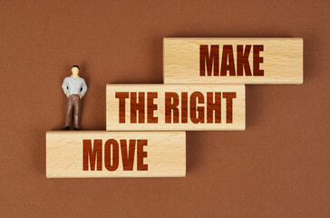 On wooden blocks with the inscription - MAKE THE RIGHT MOVE, there is a miniature figure of a...