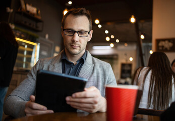 Young business man sitting and using smartphone at coffee shop