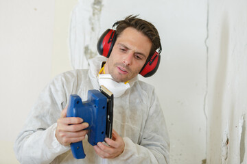 Fototapeta premium carpenter looking at his sanding machine