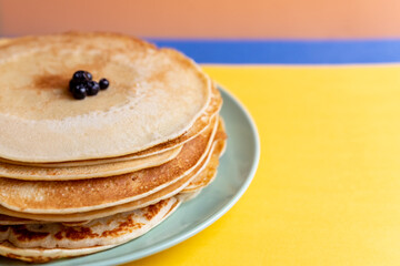 Healthy summer breakfast, homemade classic american pancakes with fresh blueornin berries. bright colorful background.copy space