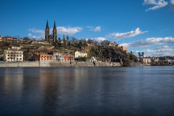Fototapeta na wymiar Gothic Basilica on Vysehrad hill are an inseparable dominant of the Prague skyline. Towering over the right bank of Vltava river, the Vysehrad hill offers the best romantic views in Prague.