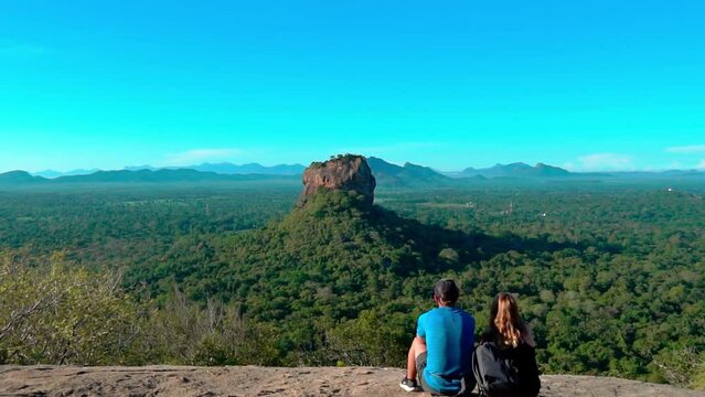 The couple in love on a Sigiriya rock admires the beautiful views at Pidurangala mountain.
