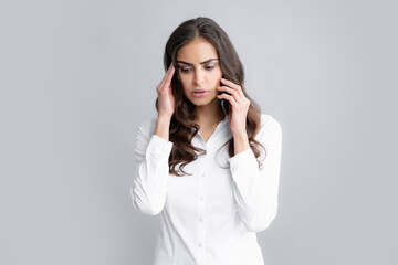 Upset sad Woman talking on phone. Young woman with mobile phone. Businesswoman with smartphone on grey background.