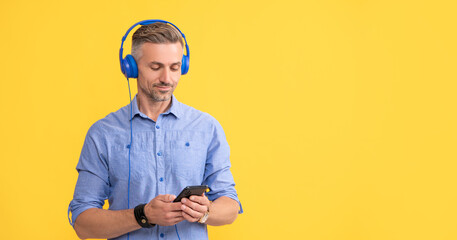 guy in headphones use smartphone. man listen music and hold phone.