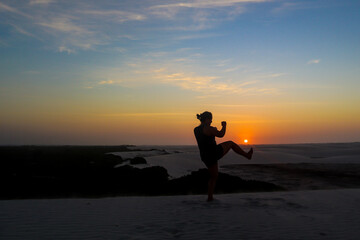 silhouette soccer player against sunset sky at  dunes