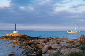 Lighthouse and Sailboat bathed in afternoon light in Potamos Liopetri fishing village, Mediterranean, Cyprus