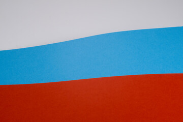Rosyjska powiewająca flaga stworzona z kolorowych arkuszy papieru. Klasyczne kolory niebieski i czerwony. 