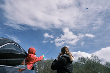 Mother and daughter flying a kite. Family outdoor activity.
