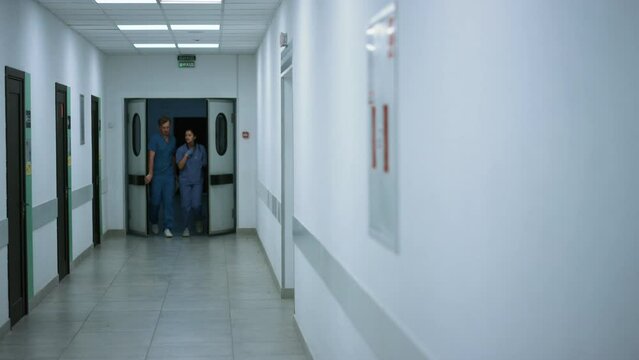 Medics colleagues walking out doors emergency room discussing covid pandemic. 