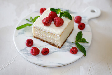 Raspberry cheesecake garnished with mint leaves. On a light background. The concept of the Israeli holiday Shavuot