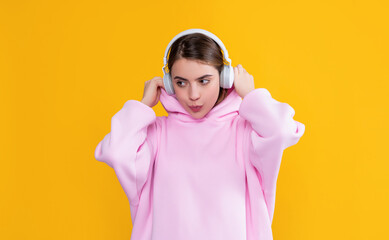 girl listen music in headphones on yellow background